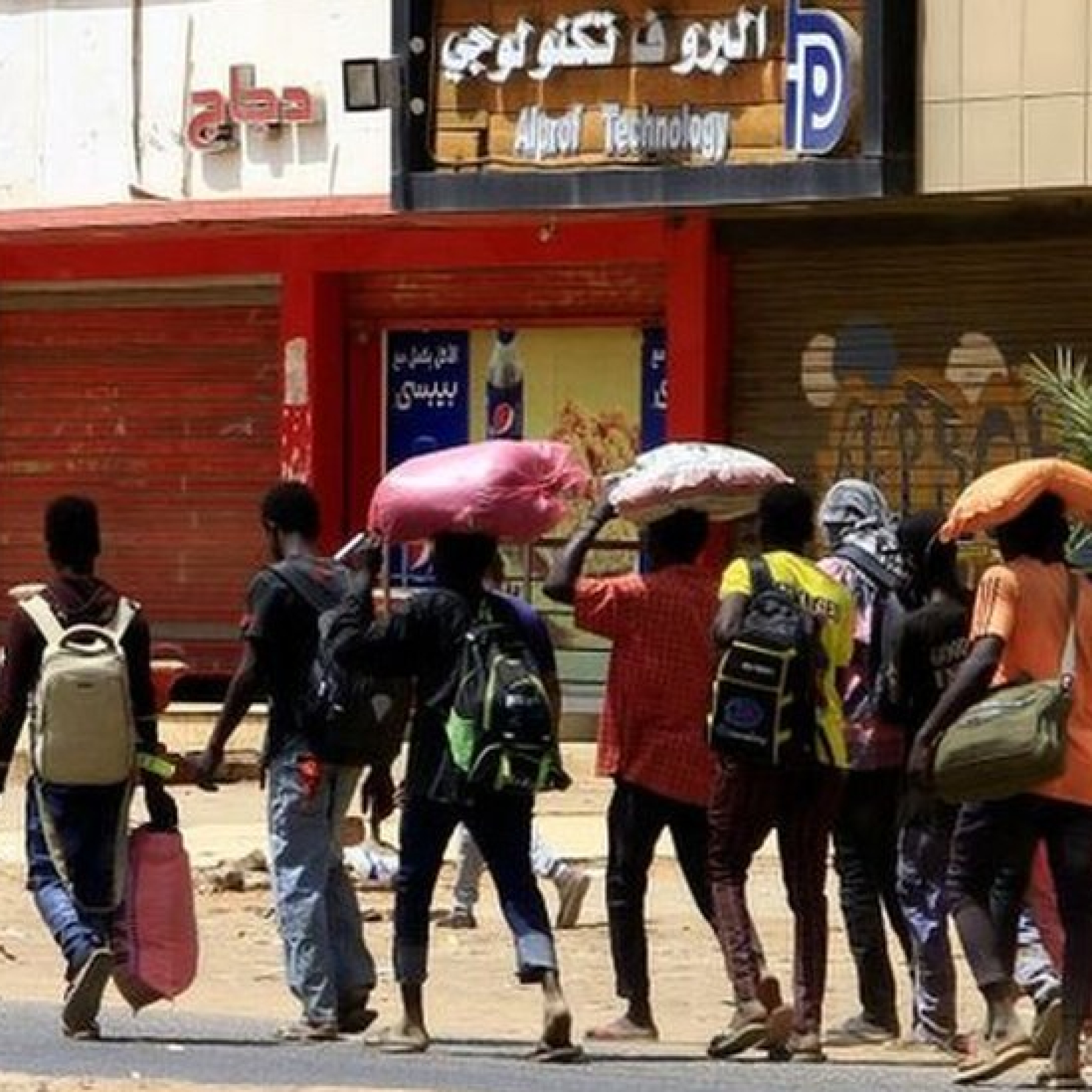 People carry their belongings down a Khartoum street on Sunday